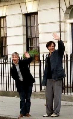 two men waving their hands in front of a building with the word ben benny on the bottom