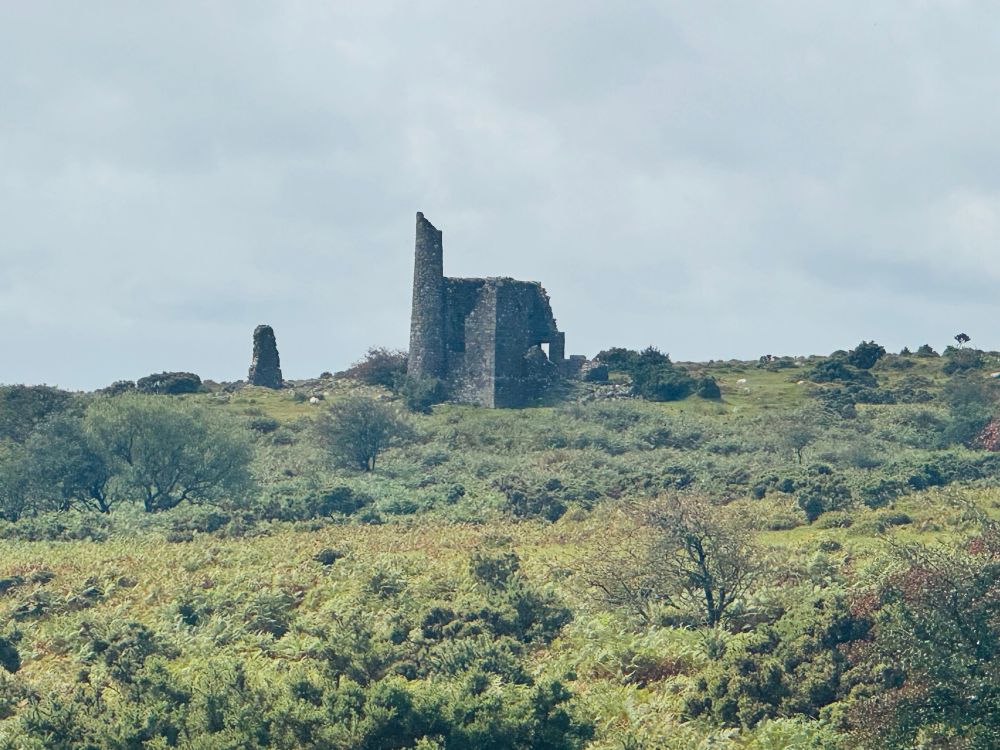Standing stones ‘The Hurlers’, in front of abandoned tin mine buildings