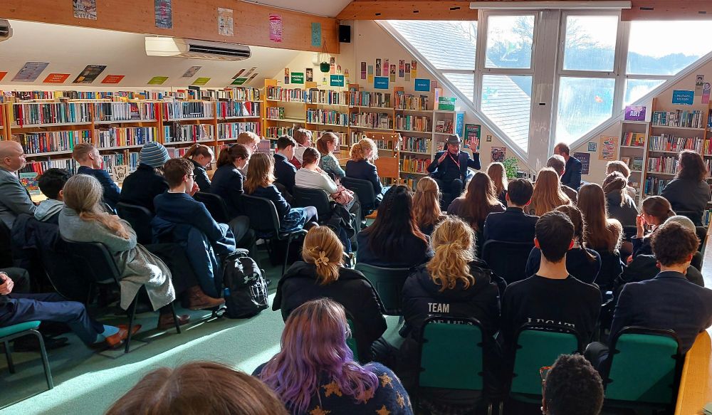 Full library with John answering a question at the front
