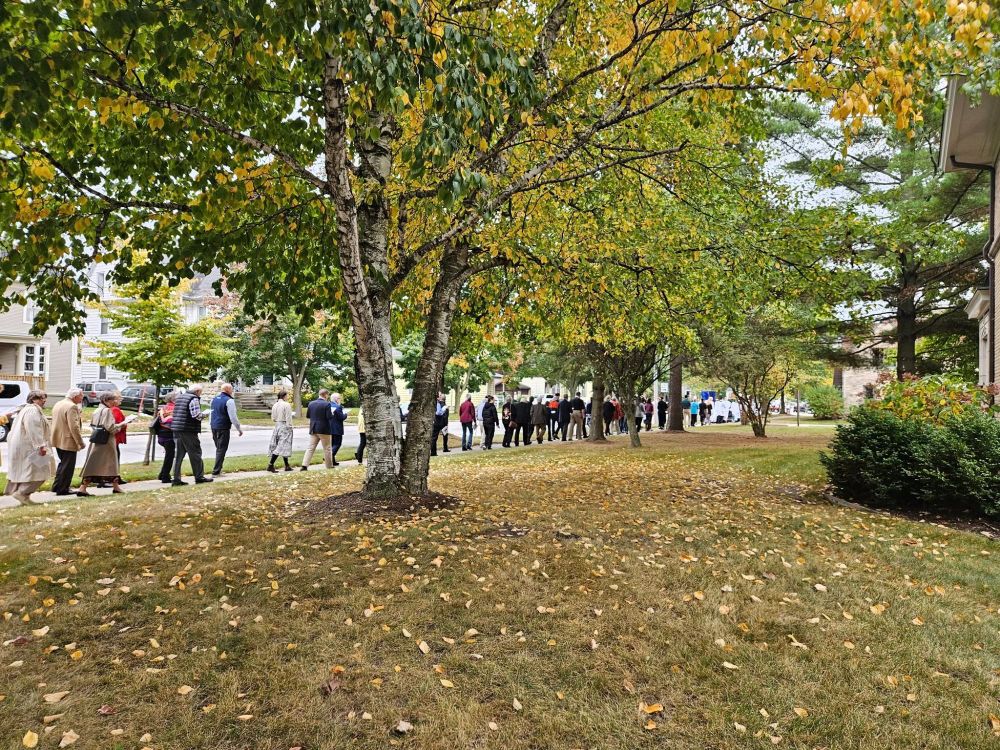 A long procession of people outside following behind the image of Our Lady of Walsingham.