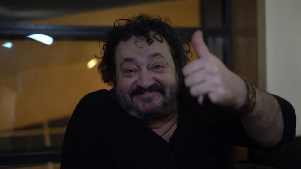 Ivan Kaye smiling at the camera and giving a thumbs up