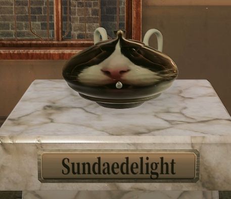 a squat Sundae teapot with two plain handles. it looks like the spout is coming out from Sundae's mouth