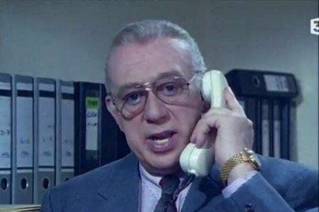 Image datée de la série Derrick. L'inspecteur parle dans un téléphone filaire.