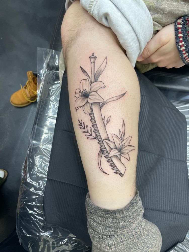 A tattoo of one of Kaine’s swords from the game NieR Replicant surrounded by two lunar tears