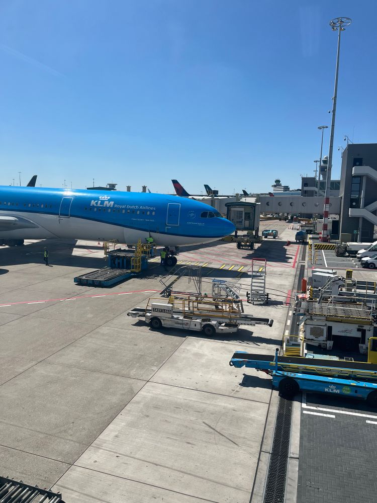 Photo of a klm plane docked at terminal. Some machinery and vehicle contraptions are in the shot but I don’t know their purpose or name 