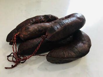 Several links of black pudding. A cased sausage made with diced pork fat, oats, barley, and pig’s blood — very dark in colour. The recipe I found calls for 2 grams of black pepper per 75cm length of sausage. It is considered a traditional delicacy in England.