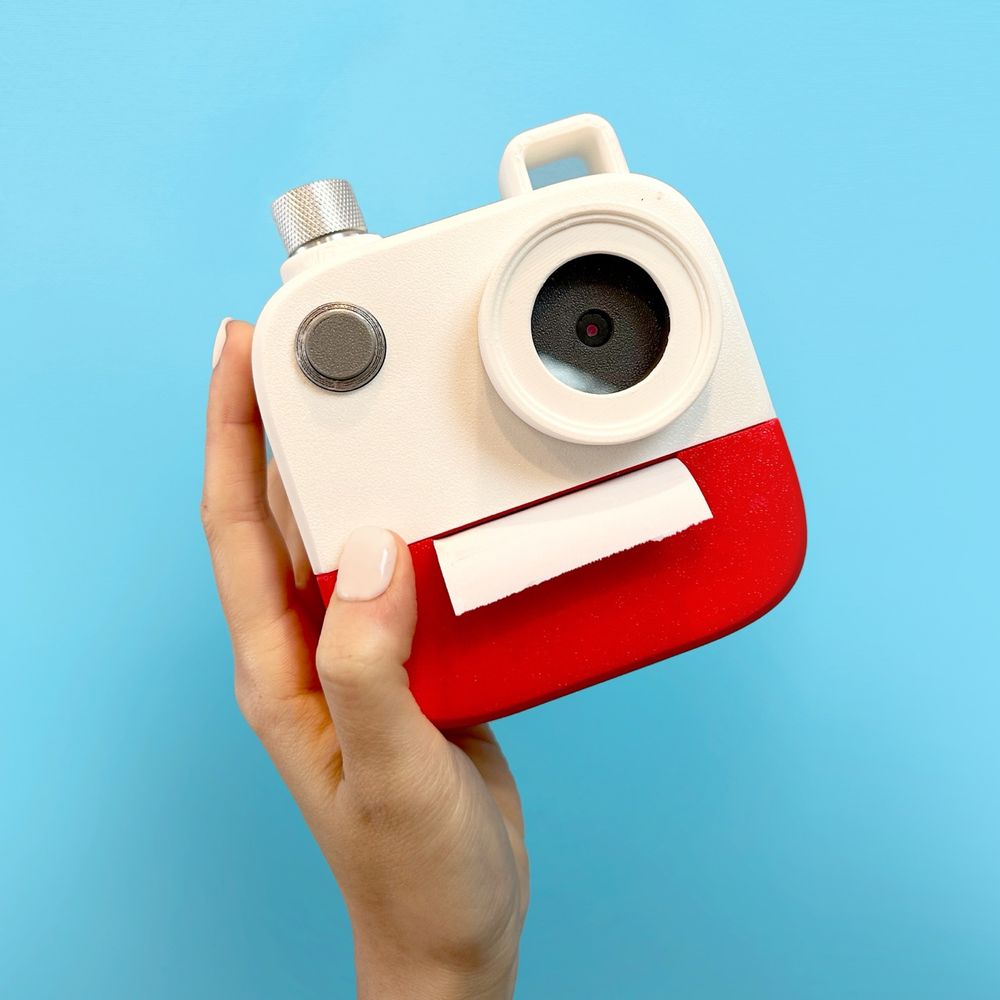 hand holding a poetry camera against a sky blue background
