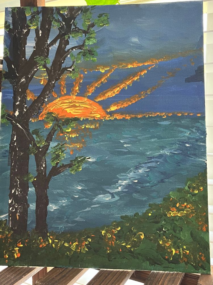 An acrylic painting of a setting sun over a white capped sea both the sea and the sky suggest a storm has recently passed. Flowers matching the yellow and gold of the sun dot the shoreline where two trees put out new spring leaves. It should be noted that my description of this painting likely makes it sound better than it is.