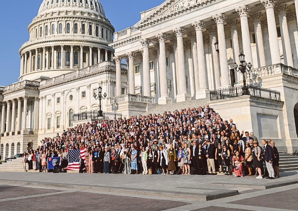 Photo of 850+ volunteer lobbyists from Citizens' Climate Lobby standing on the steps of the Capitol on a beautiful summer morning with an American flag and the Capitol dome in the background.