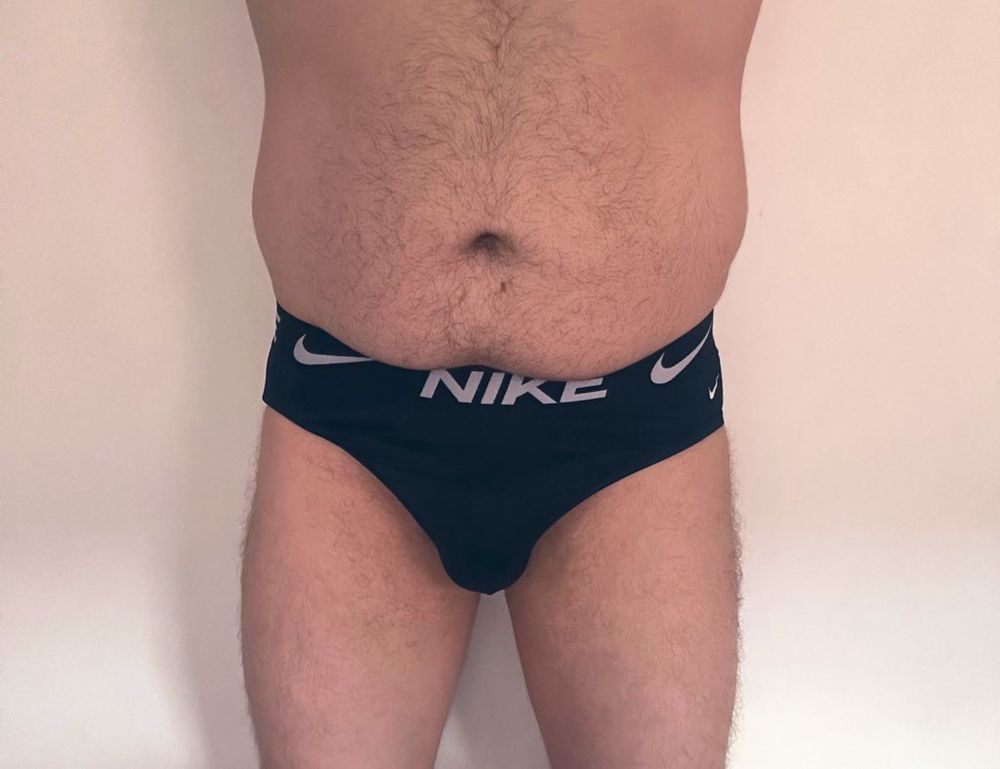 A man wearing a pair of black Nike sports briefs posing for the camera