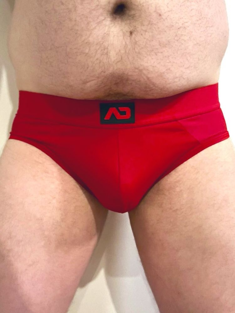 A man wearing Red AD briefs 