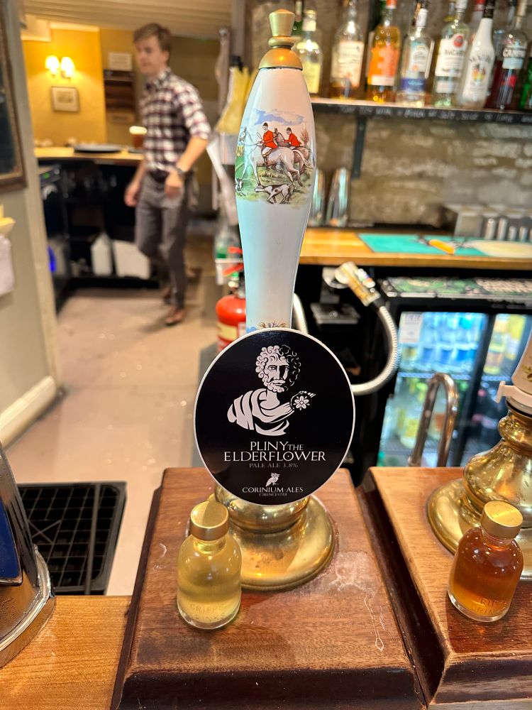 A beer pump. Black sign with “PLINY THE ELDERFLOWER” on it.