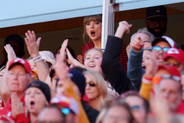 Taylor Swift looks on as the Chiefs make a play. She is just visible over the crowd, and has her mouth open seemingly in surprise. Photo by Jamie Squire