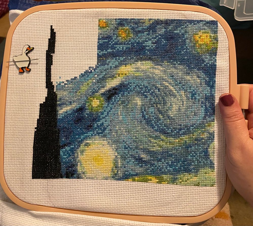 In progress cross stitch of VanGogh’s ‘Starry Night’ with half of upper sky completed 