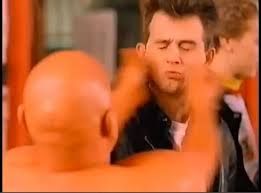 The bald orange man slapping a random stranger in a leather jacket
