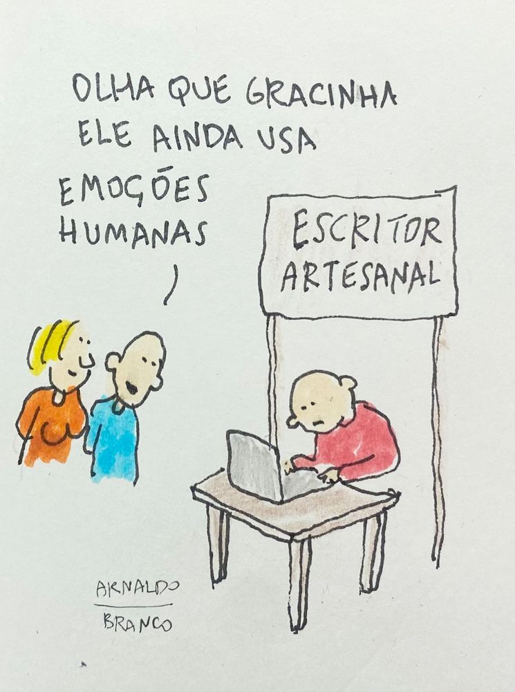 Cartum de Arnaldo Branco (Kkkkk eu mesmo): um cara escrevendo em um laptop em uma barraquinha de feira com a placa: "Escritor artesanal".  Um casal o observa digitar e comenta: Olha que gracinha ele ainda usa emoções humanas