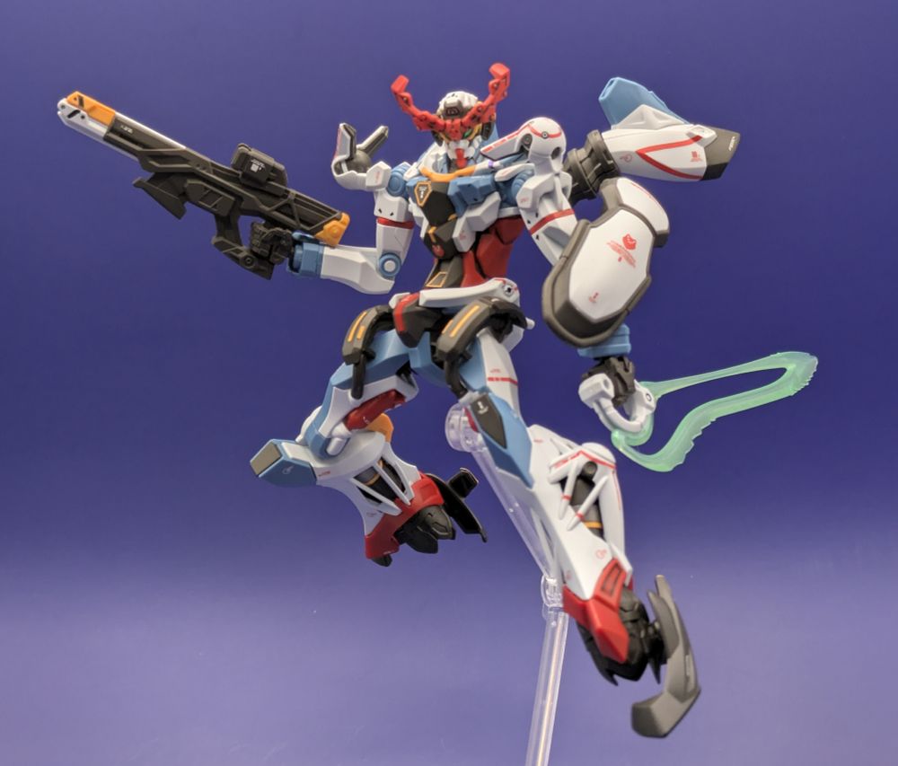 The HG GQuuuuuuX gundam model kit mounted on an action base, holding its gun and beam saber.