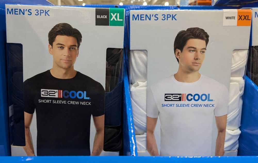 Photo of 2 side by side boxes of men's undershirt-style tee shirt 3-packs on a store shelf. Black shirts on the left, white on the right. The box covers have photos of the same male model (caucasian, dark brown hair) in different poses. In the black shirt photo, he is looking at the camera with a quiet satisfaction, pleased with his life decisions. In the white shirt photo, he is gazing off slightly down and to his left, haunted by the specters of his past. He remembers an autumn hillside, how she loved him and how he took her for granted