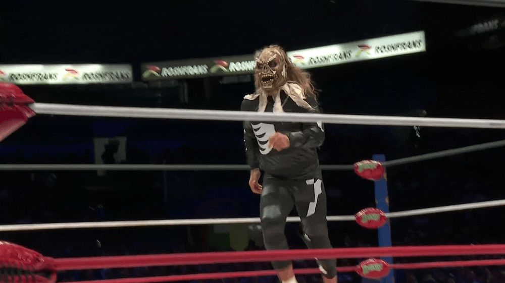 Difunto runs to the corner of the ring, springs up to the top rope, and jumps off to hit Atlantis Jr. on the floor with a diving crossbody