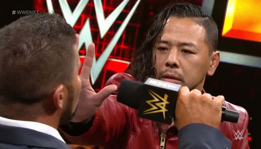 Shinsuke Nakamura holds his hand up in Bobby Roode’s face to silence him
