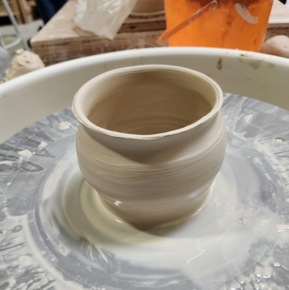 A halfway decent clay pot on a pottery wheel
