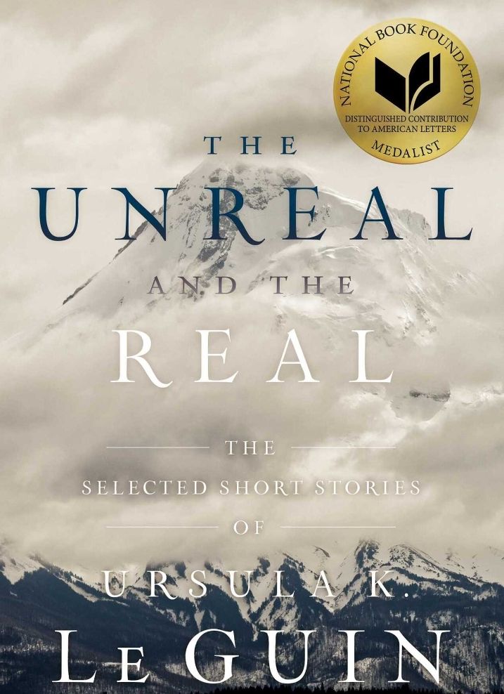 Capa do livro “The Unreal and the Real: the selected short stories of Ursula Le Guin”. A capa é um cenário montanhoso coberto de neve. No canto superior direito, tem um selo dourado de medalhista da National Book Foundation.