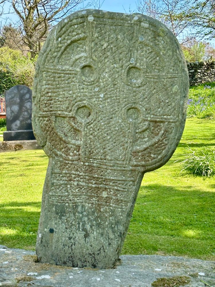 “The cross itself is filled with a complex interlace design and the ring which circles the cross is divided into three bands, separated by projecting borders; each ring is decorated with further interlace. The upper part of the cross shaft is decorated with four bands of plait-work.”
Archaeological sites of the Isle of Man guidebook.
Andrew Johnson & Allison Fox