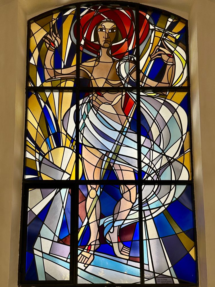Christ steps out of the tomb,  his robes & the golden light swirl around him.