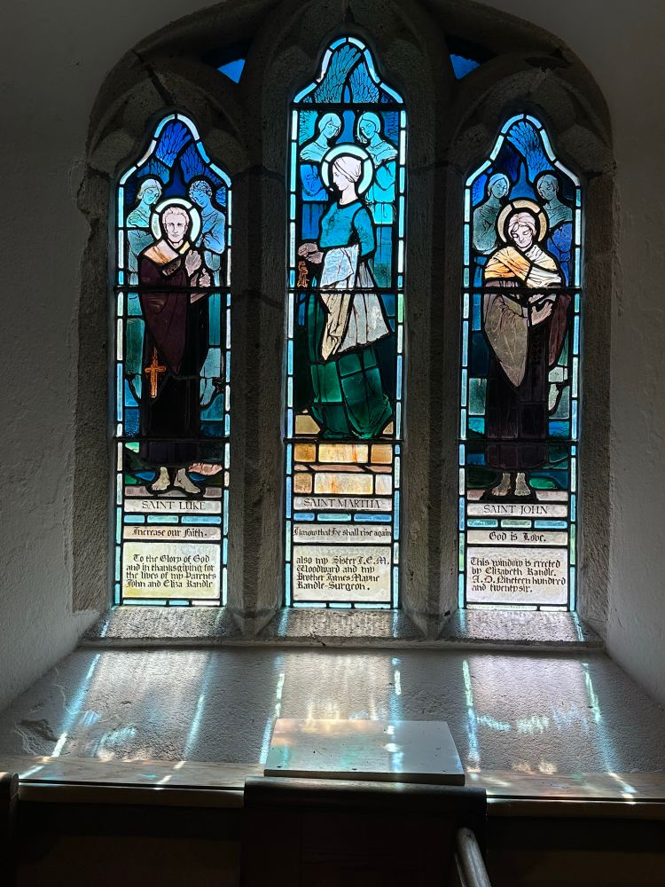 A three light window casting a shadow onto the wide window sill.