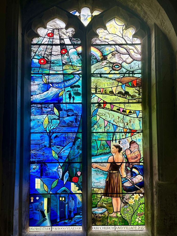 A colourful window. Dark blue to left representing winter & adversity, green to right for spring & optimism. A sad figure on the left looks to a strong figure on the right.