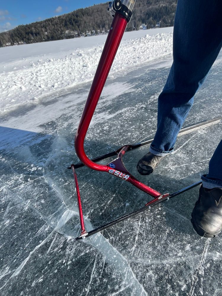 Red ice sled on a frozen lake with the label “Esla”