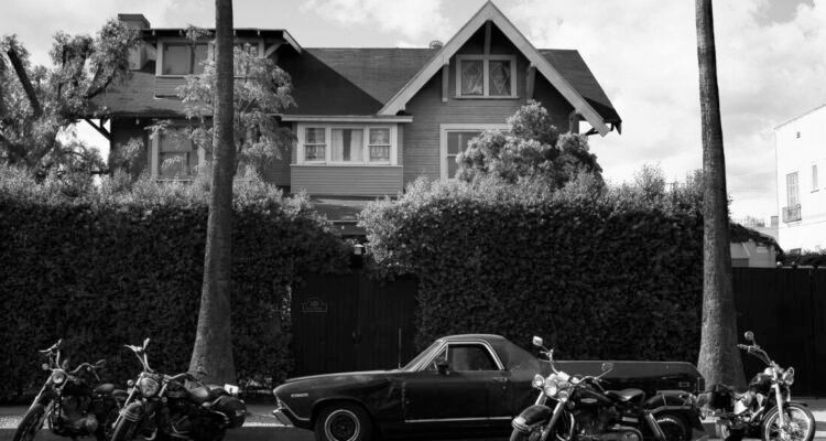 A black and white photo of the curbside view of  the Tom of Finland House, designated as a Historical Cultural Monument in 2016.  https://www.laconservancy.org/learn/historic-places/tom-of-finland-house/