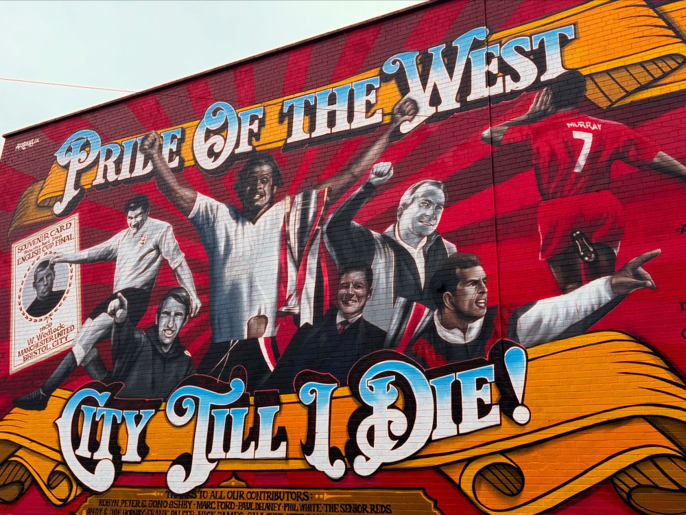 A mural celebrating Bristol City Football Club with the words “Pride of the West” and “City Till I Die!” alongside portraits of players from different eras, a trophy, and a vintage 1909 cup final card.