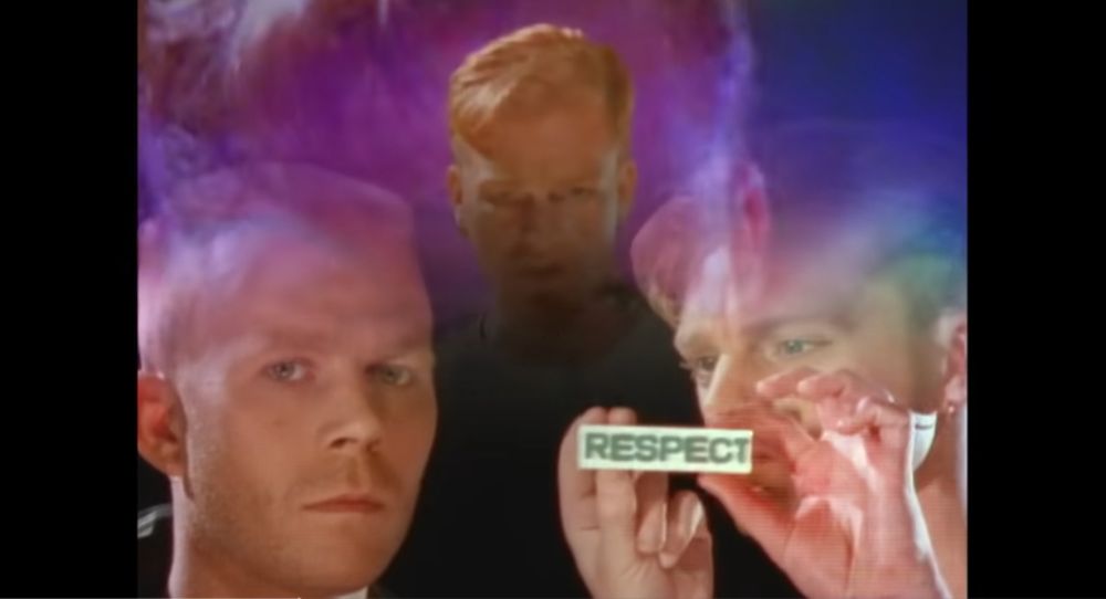 A steal from the video for a little respect by erasure. The keyboard one is handing a little item with respect written on it to the singing one. He is literally giving a little respect to him.