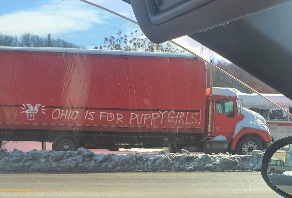 Red semi-truck spray painted to say "OHIO IS FOR PUPPYGIRLS!"