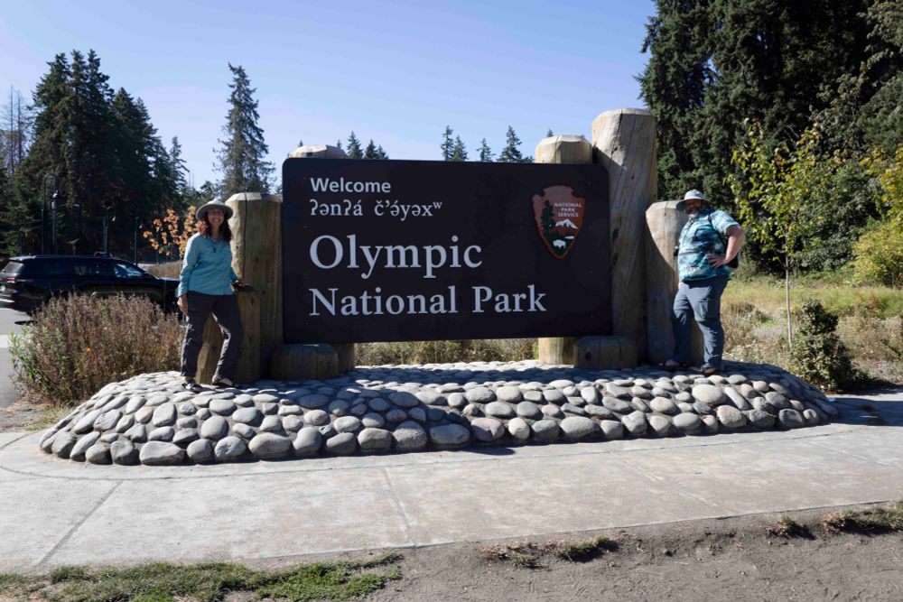 Two people with Olympic National Park sign