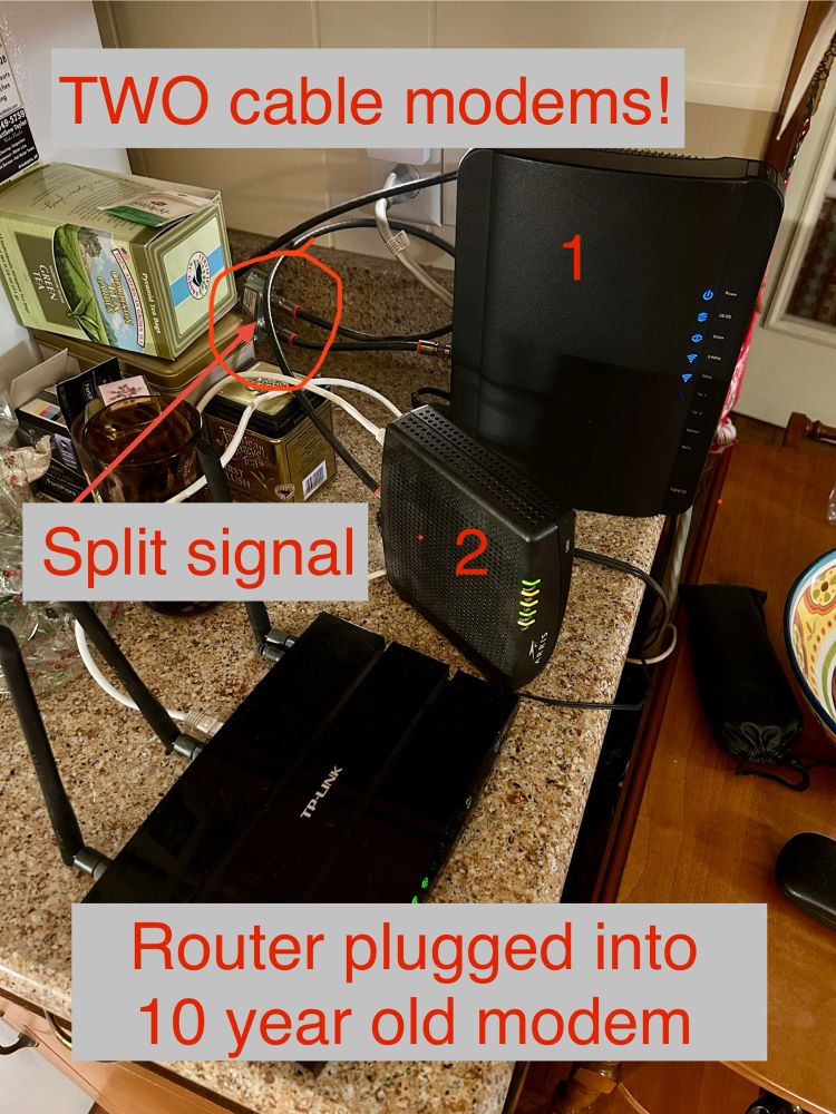 A pic of my parents’ network setup, with two separate cable modems fed from a split signal. The WiFi router is plugged into the ten year old modem. The new modem is blissfully free of connections to, like, anything. 