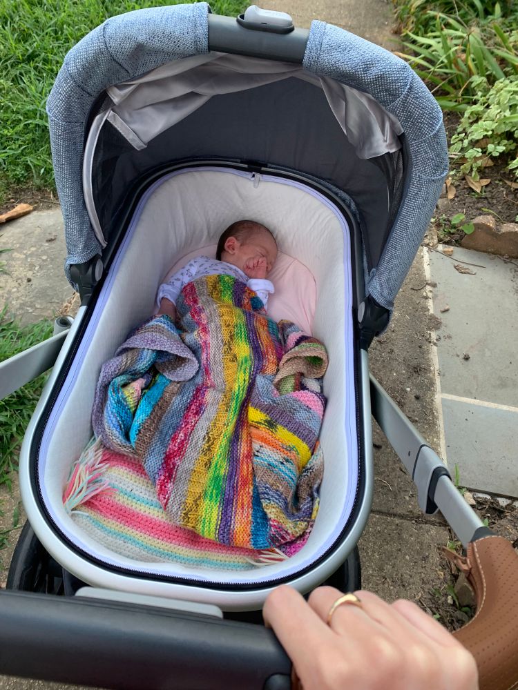 A very cute baby is snoozing in a stroller and covered in a vividly-striped blanket about thrice her size, and I realize that a) I probably should have knit with a gauge and b) I have no idea what size babies are. 
