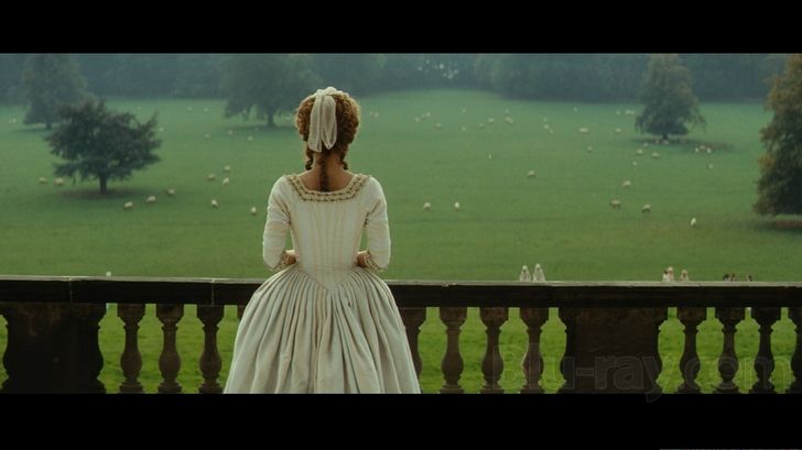 An 18th century woman stands at a balcony, her back to the camera. (Still from the 2008 movie "The Duchess")