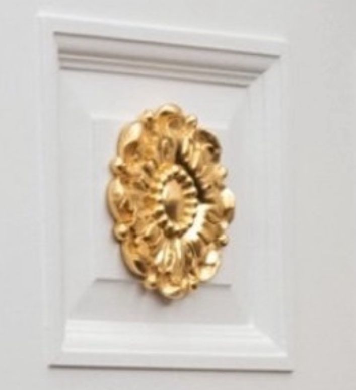 A faux gold medallion stuck on the recessed door panel