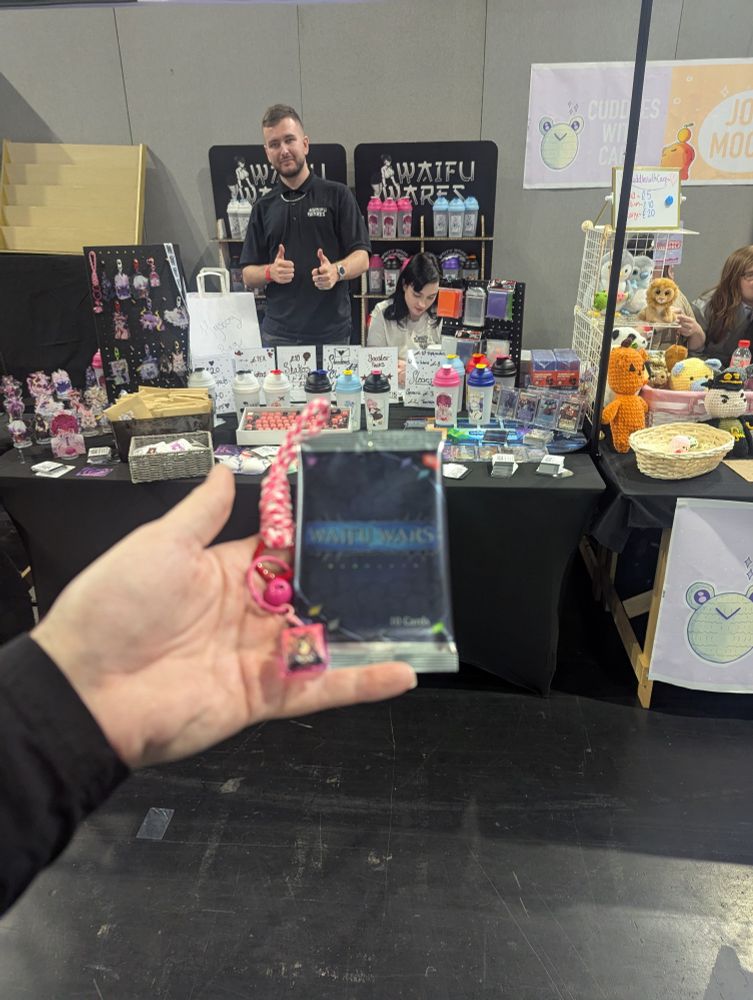 Holding merch purchased from Waifu Wares stall at Birmingham MegaCon UK