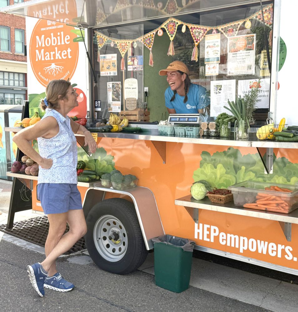 Mobile Market uses their profits for the HEP homeless programs that helps disinfranchised people get back on their feet again. 

Image is of the small food truck like mobile vehicle with fruits and vegitables avaiable for sale. Two ladies talk and laugh together at the market.