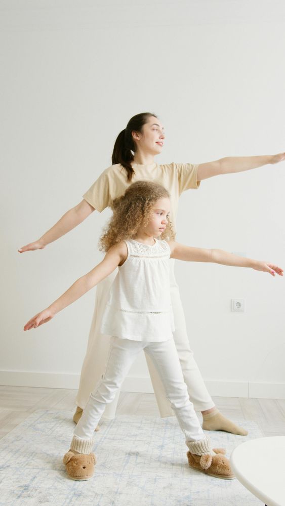 A woman and child performing yoga exercises indoors for a healthy lifestyle.