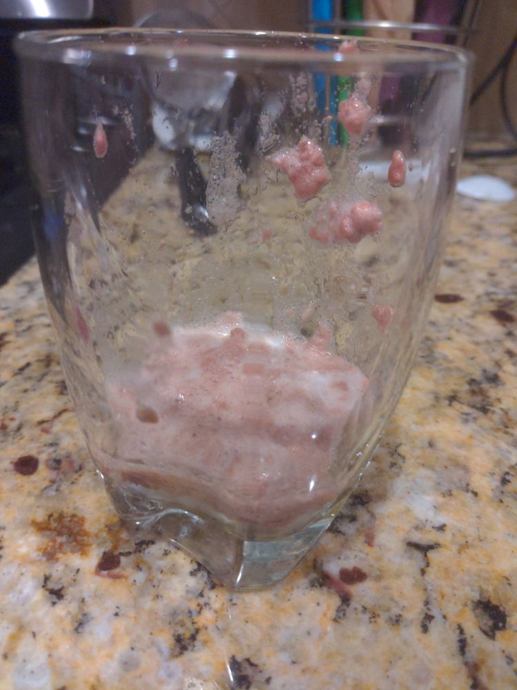 Glass cup with liquid fat and froth all inside it