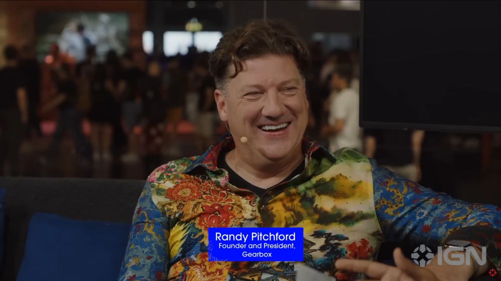 Randy Pitchford, fondateur et président de Gearbox, en interview avec IGN. Il sourit et porte une chemise multicolore aux motifs excentriques.