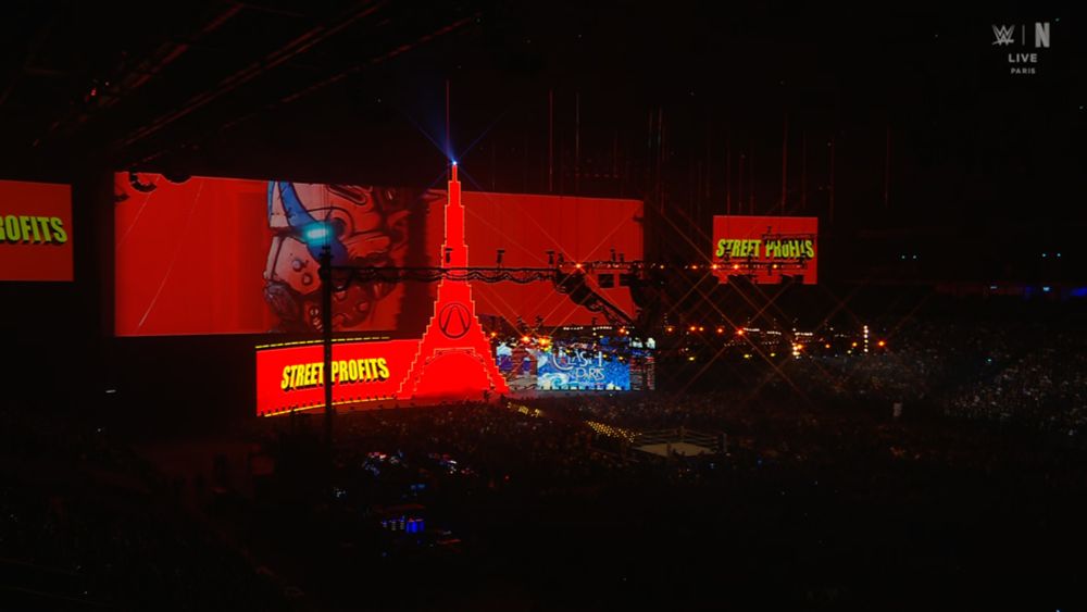 Capture d’écran de WWE Clash in Paris 2025. Les écrans géants affichent l’entrée des Street Profits, avec un visuel inspiré de Borderlands montrant le logo du jeu sur une tour Eiffel et un personnage à côté.