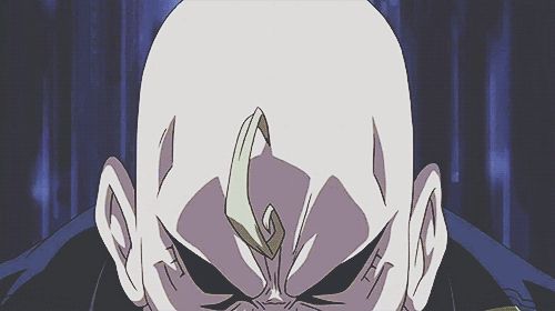 Animated GIF of the character Alex Armstrong from the anime Fullmetal Alchemist flexes his muscles so much his military jacket explodes off of his body to reveal his buff torso