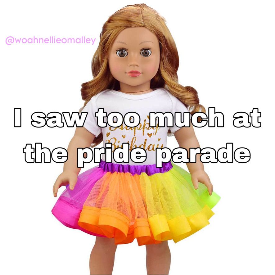 A tan doll with bright pink lipstick, caramel colored curly hair, brown eyes, and a slightly shocked facial expression stands in front of a plain white background. She is wearing a white, short sleeved t-shirt that says "Happy Birthday" in gold cursive writing with small gold hearts surrounding the shirt's text and a tutu with a purple elastic waistband and  neon pink, orange, yellow, and neon green tulle. The image text says, "I saw too much at the pride parade"