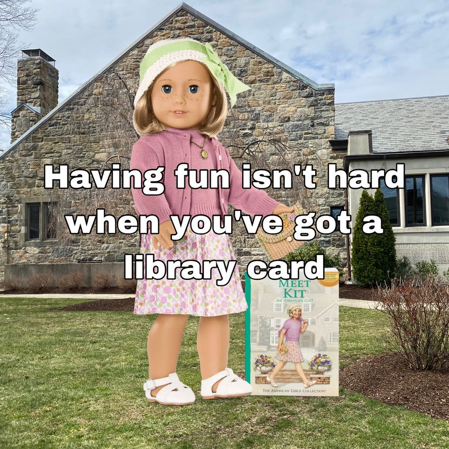 A White doll with blue eyes, freckles, and a chin-length blonde bob wearing a white knit hat with green ribbon on the brim, a mauve sweater set, a white pleated skirt with mauve, green, and orange flowers printed all over, and white canvas sandals is standing in front of a stone library building. She is holding a tan clutch with orange and pink flowers embroidered on the flap. The image text says, "Having fun isn't hard when you've got a library card"