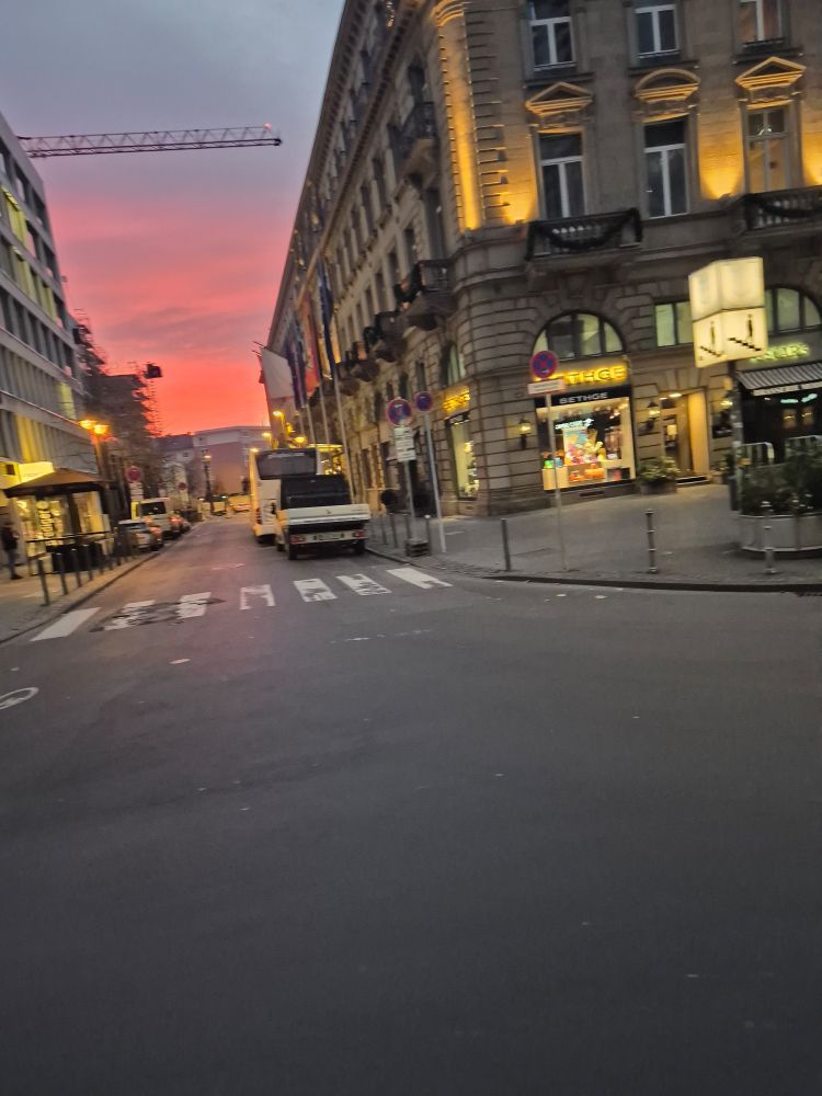 Rpsaroter Himmel zwichen Häuserschluchten rechts der Frankfurter Hof ein Luxushotel
